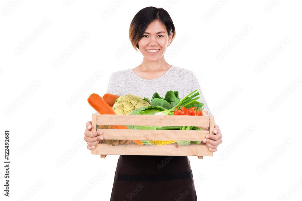 一位面带微笑的女员工拿着装有农场新鲜有机蔬菜的木箱的肖像