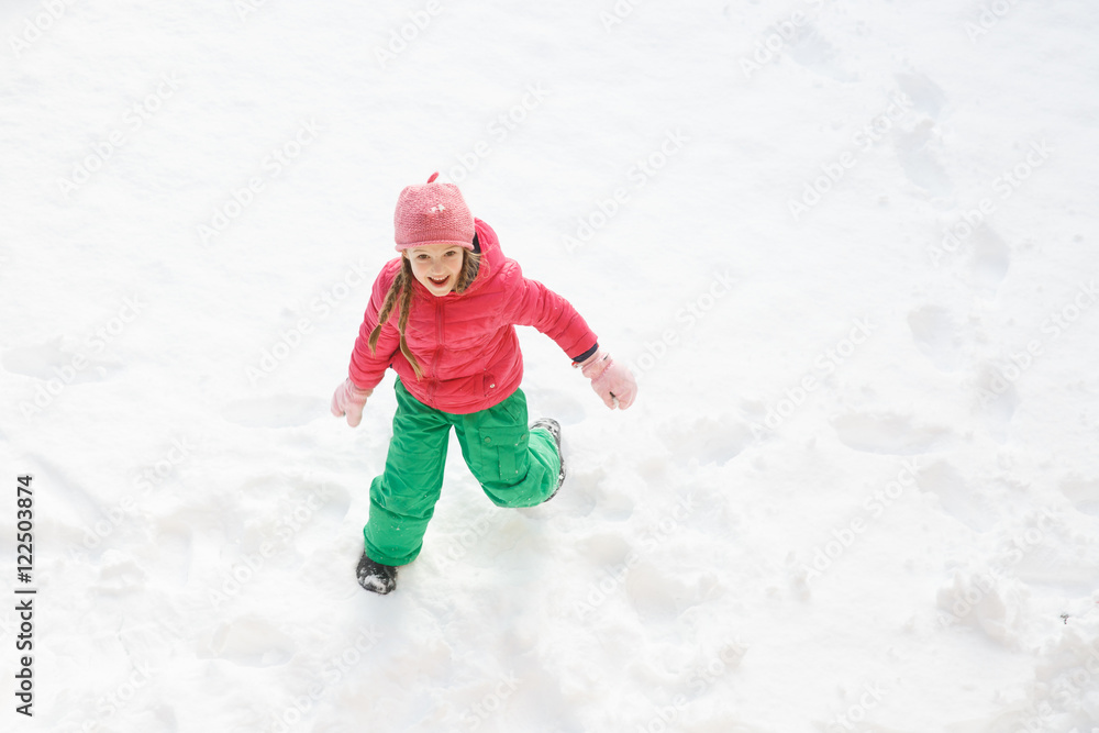 留着辫子的顽皮女孩在雪地里玩耍和奔跑