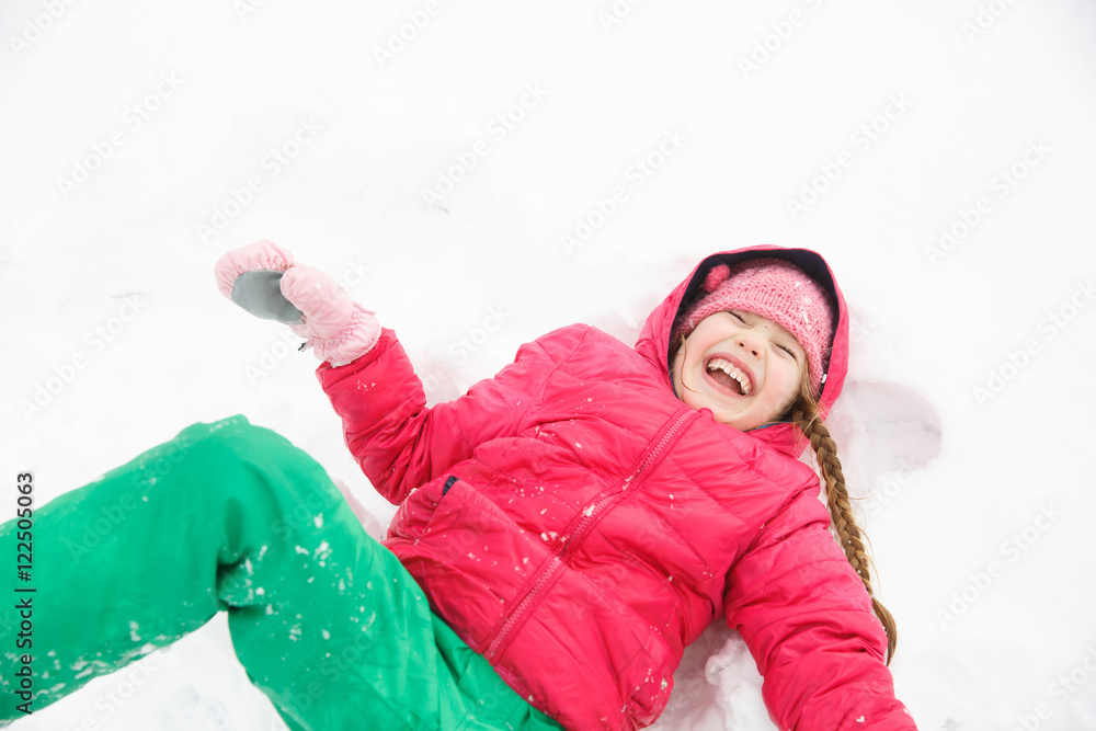 顽皮的女孩在雪地里玩耍，成为雪天使