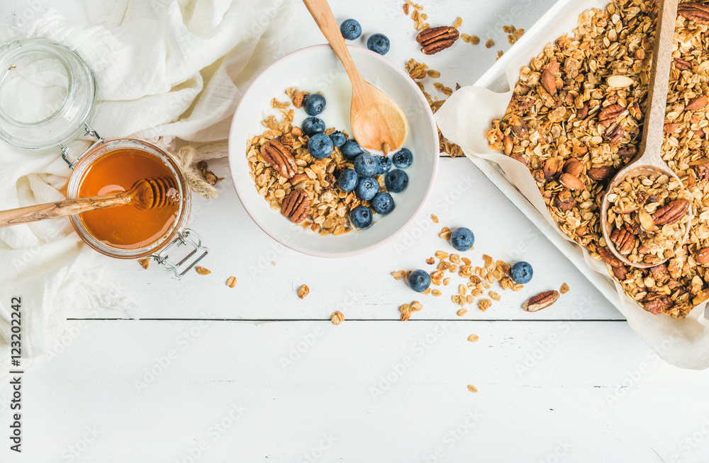 健康早餐套装。燕麦格兰诺拉麦片配坚果、酸奶、蜂蜜和蓝莓，装在白木碗里