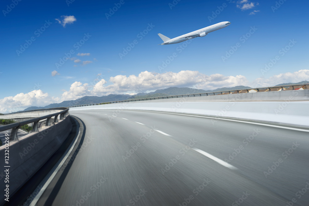 高速公路立交桥的运动被蓝天和飞机模糊了。