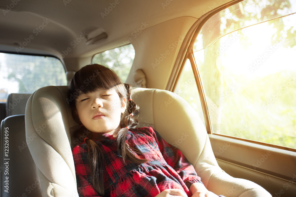 睡在儿童汽车座椅上的小女孩