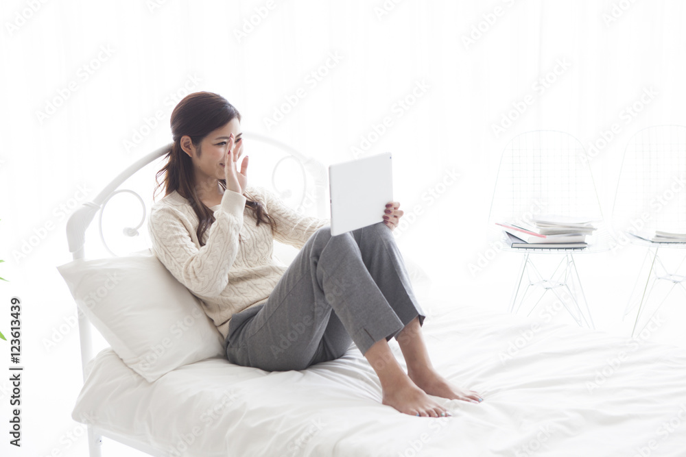 女人在床上的平板电脑上有一部视频电话