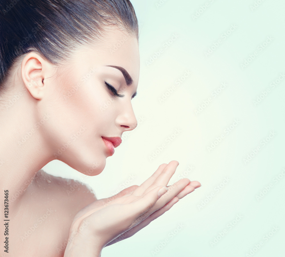 拥有完美皮肤的美容水疗女性在张开的手掌上展示出空的复制空间