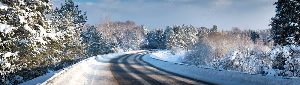 汽车在被雪覆盖的冬季道路上行驶