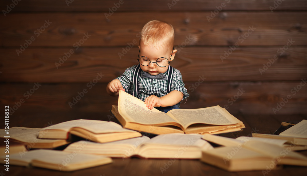 funny baby with books in glasses