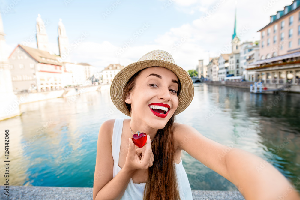 年轻的女游客在苏黎世市的河流和老城区拍摄城市景观自拍
