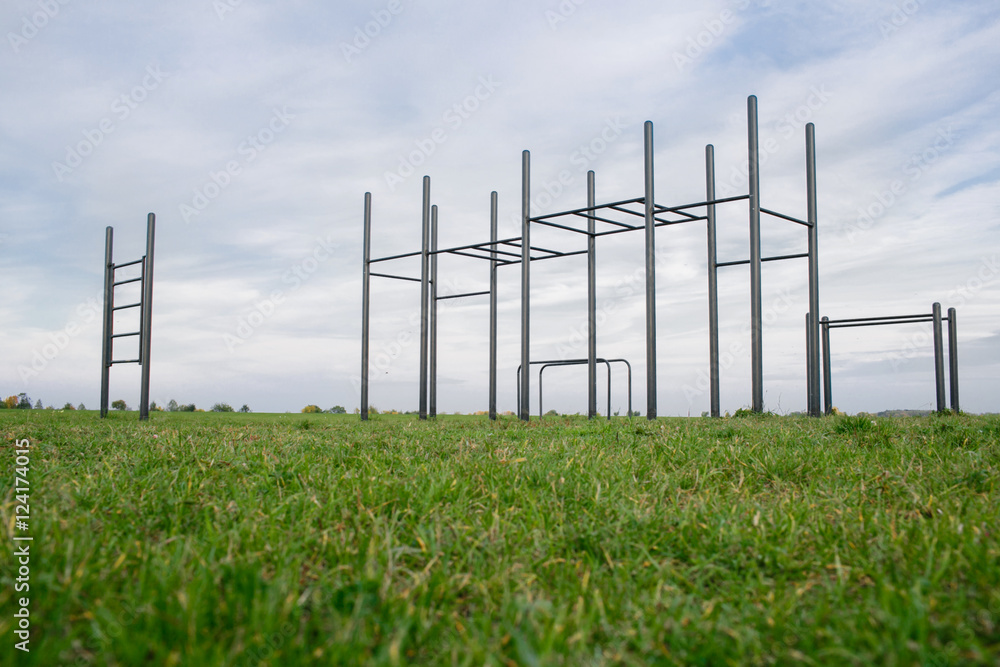 Public training ground in a park. street workout and horizontal bar on green grass