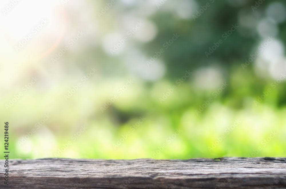 背景为散焦的模糊树上的空木板桌