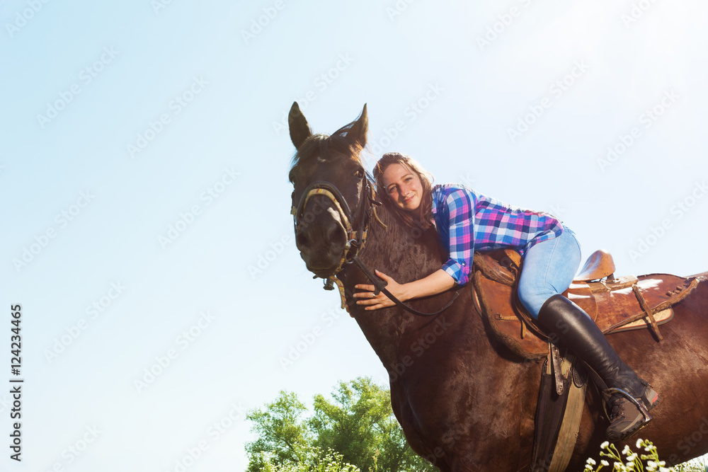 年轻女子拥抱她的马的户外肖像