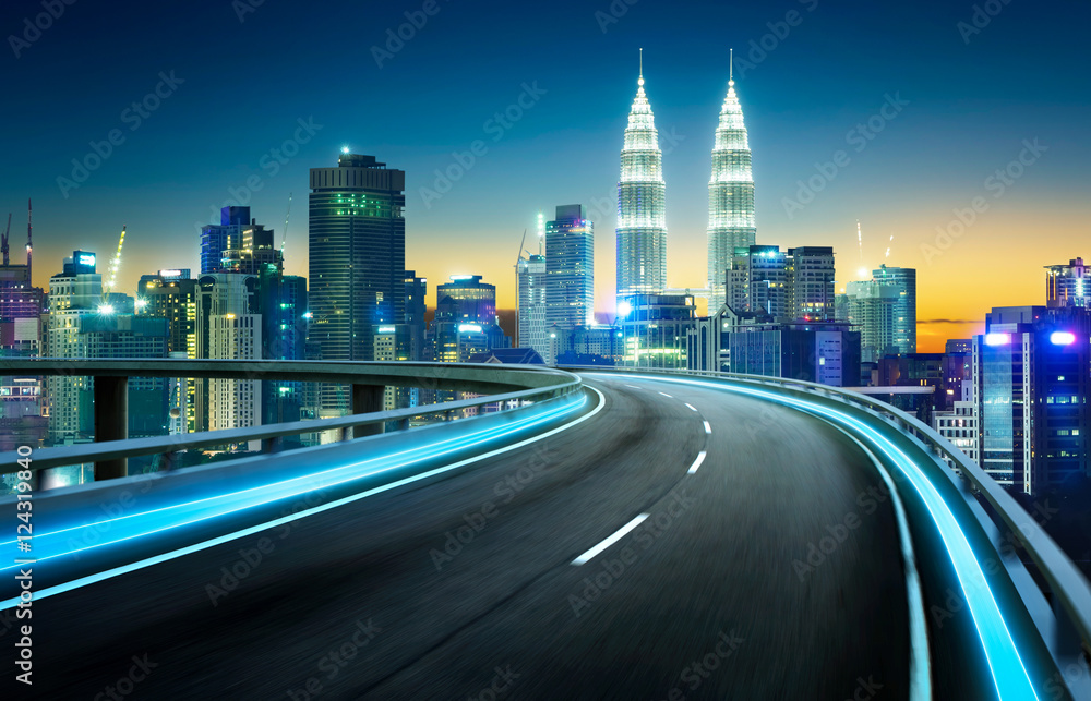 Blue neon light highway overpass motion blur with city  skyline background , night scene .