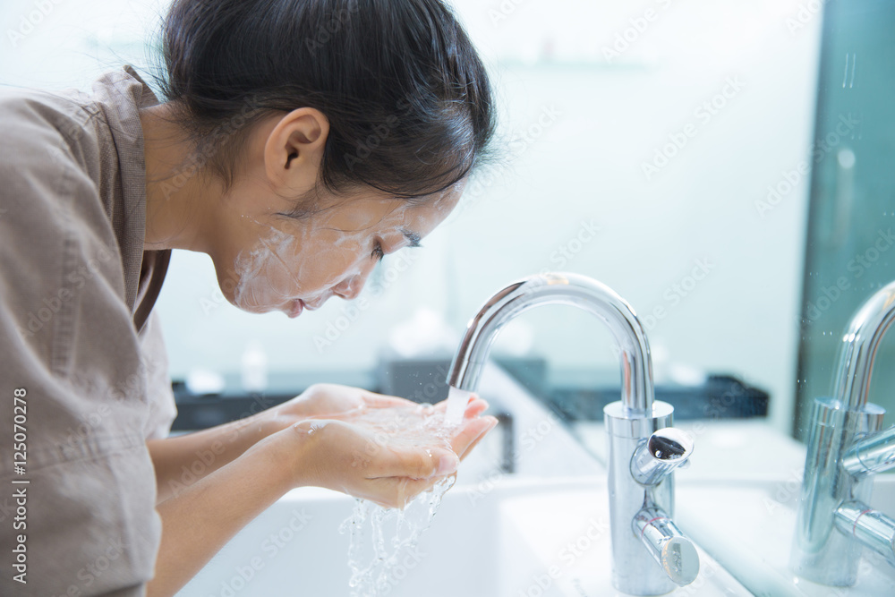 亚洲女性在浴室用泡沫清洗干净