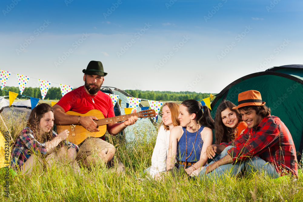 朋友们在露营旅行中欣赏吉他音乐