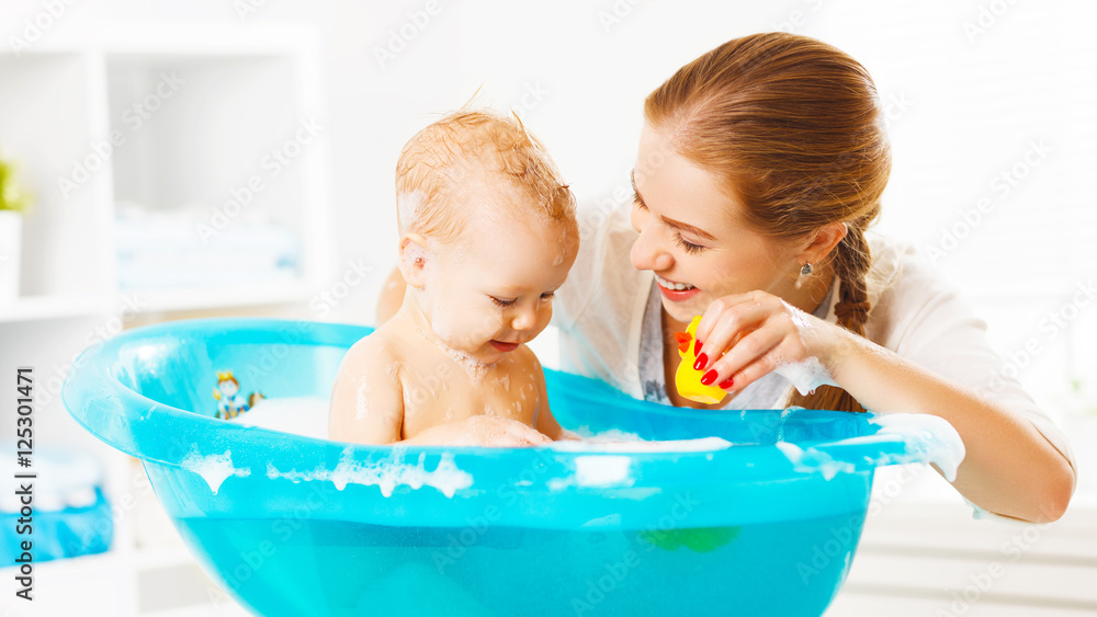 幸福的家庭妈妈在浴缸里给宝宝洗澡