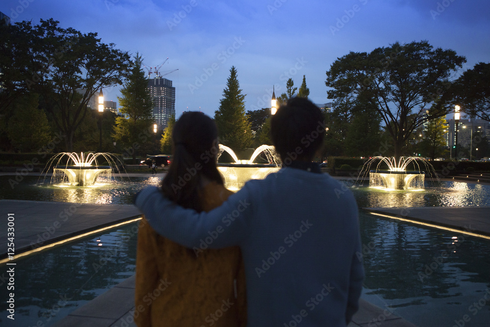这对夫妇在公园的夜晚形成了一个肩膀