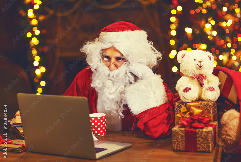 Christmas. Santa Claus with laptop reading letter