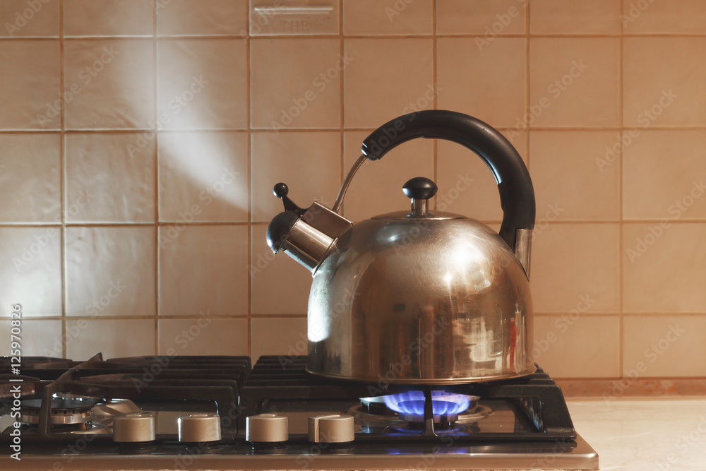 水在煤气炉上的金属茶壶里沸腾。