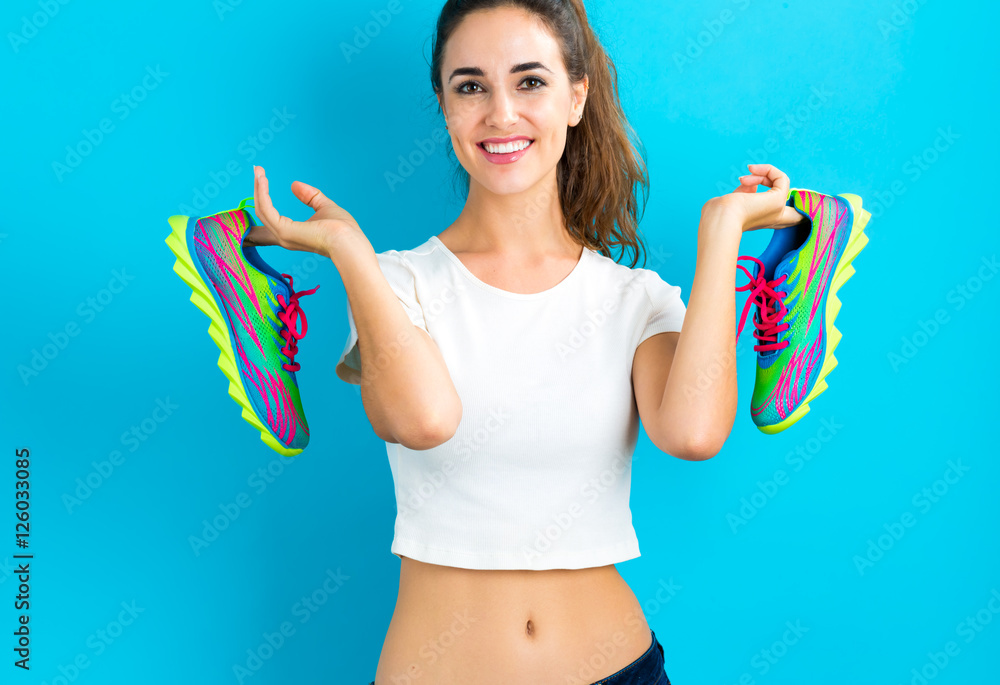 Happy young woman holding shoes