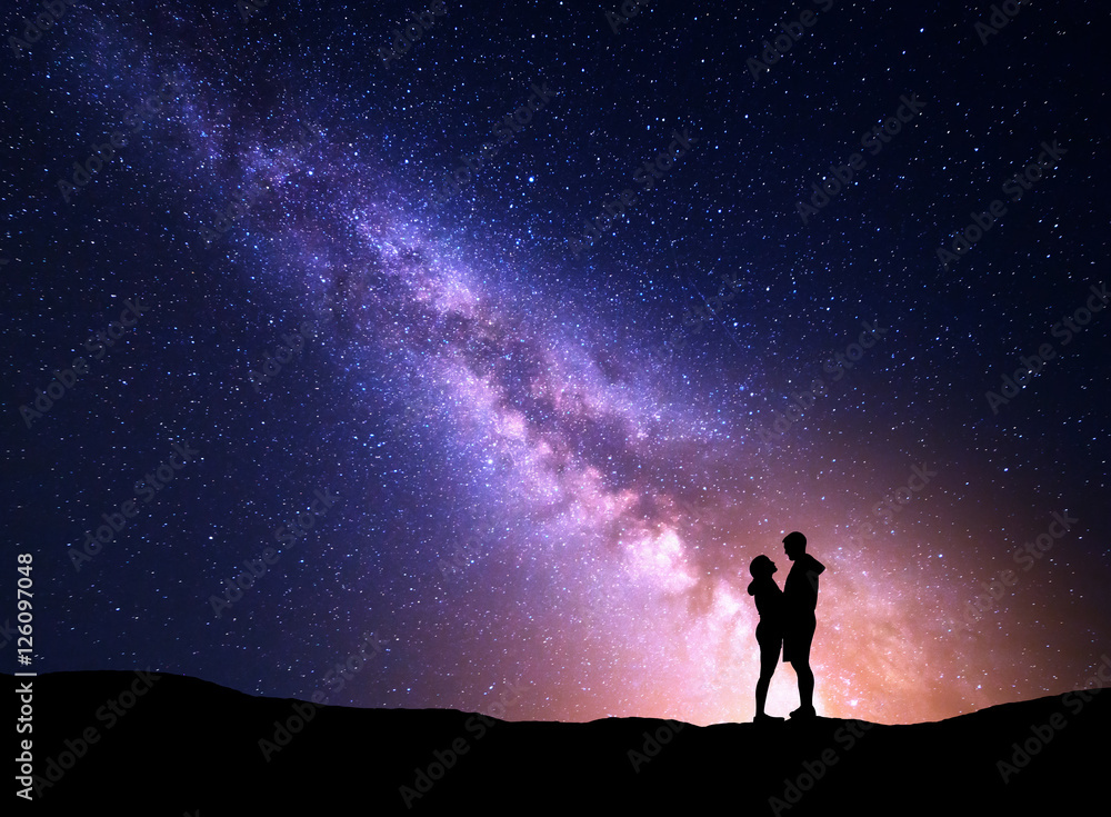 银河与人的剪影。风景与夜空。站在上面的男人和女人