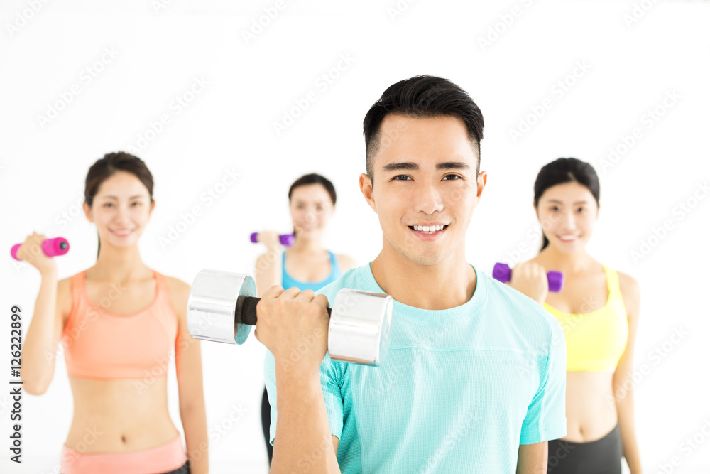 微笑的年轻健身团体在健身房伸展运动