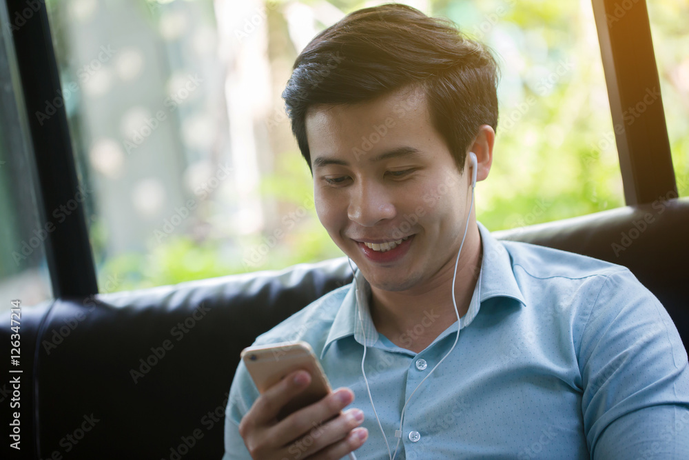 亚洲年轻男子在咖啡馆玩游戏在线智能手机