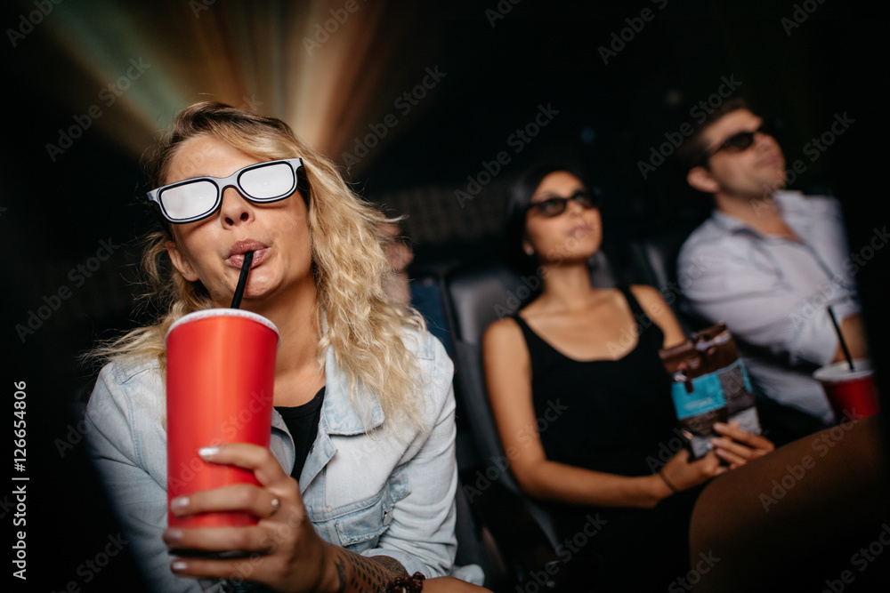 年轻女子喝冷饮看3d电影