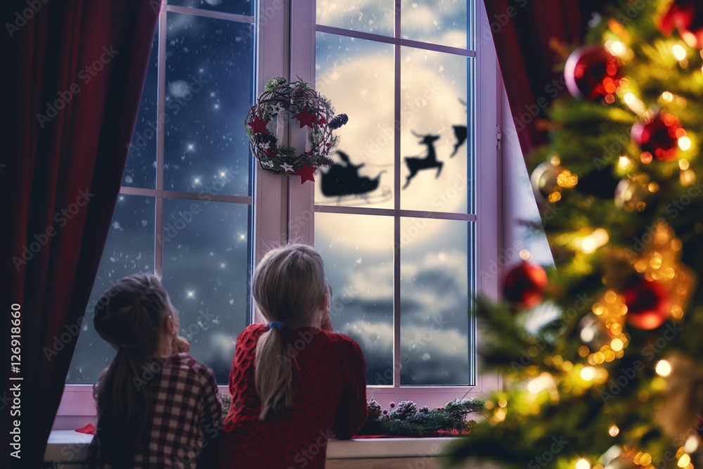女孩坐在窗边看着圣诞老人