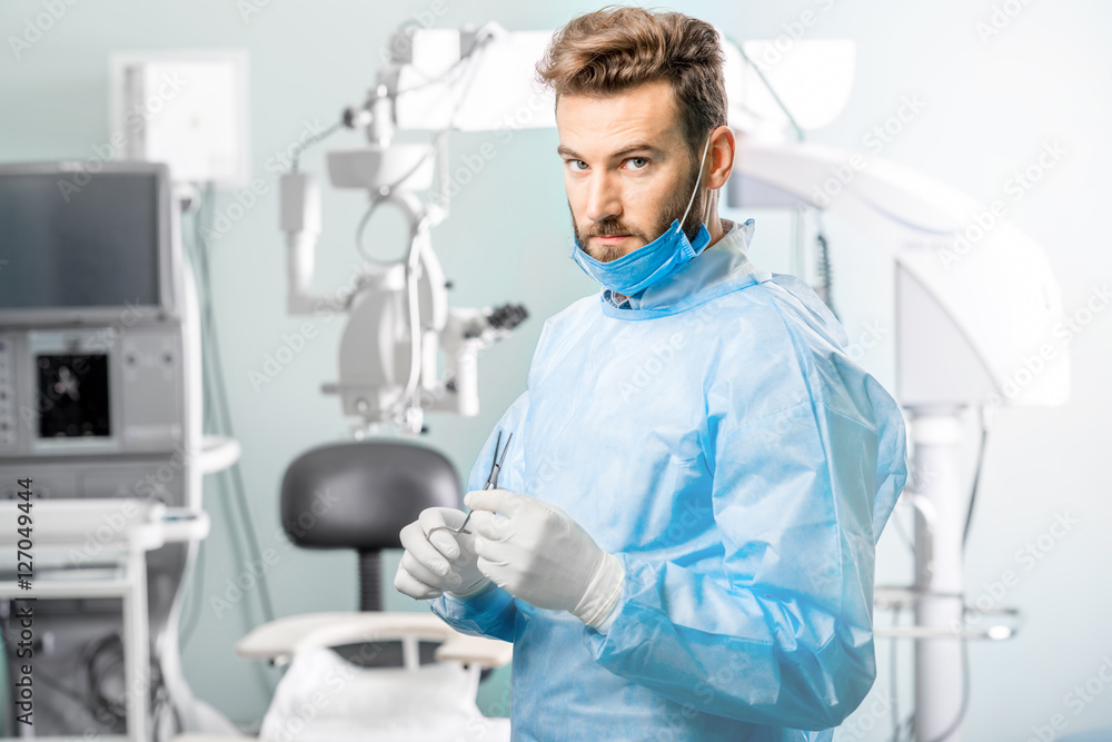 手术室里拿着剪刀的外科医生肖像，背景是手术显微镜