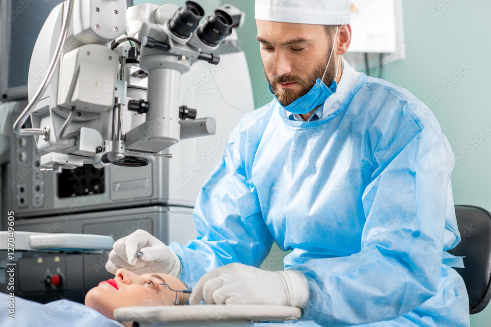 外科医生在手术室使用手术显微镜对女性患者的眼睛进行手术