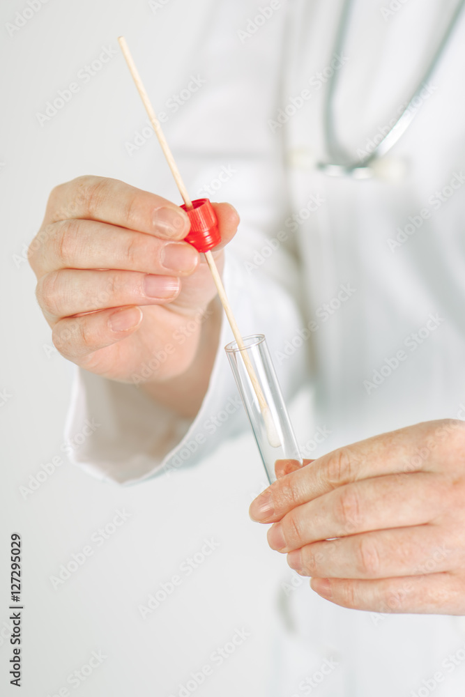 Female medical specialist holding buccal cotton swab and test tu
