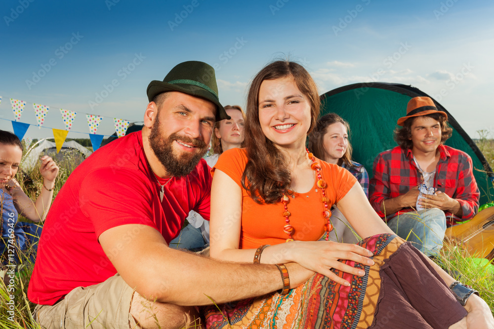 幸福的情侣坐在露营地的草地上相爱
