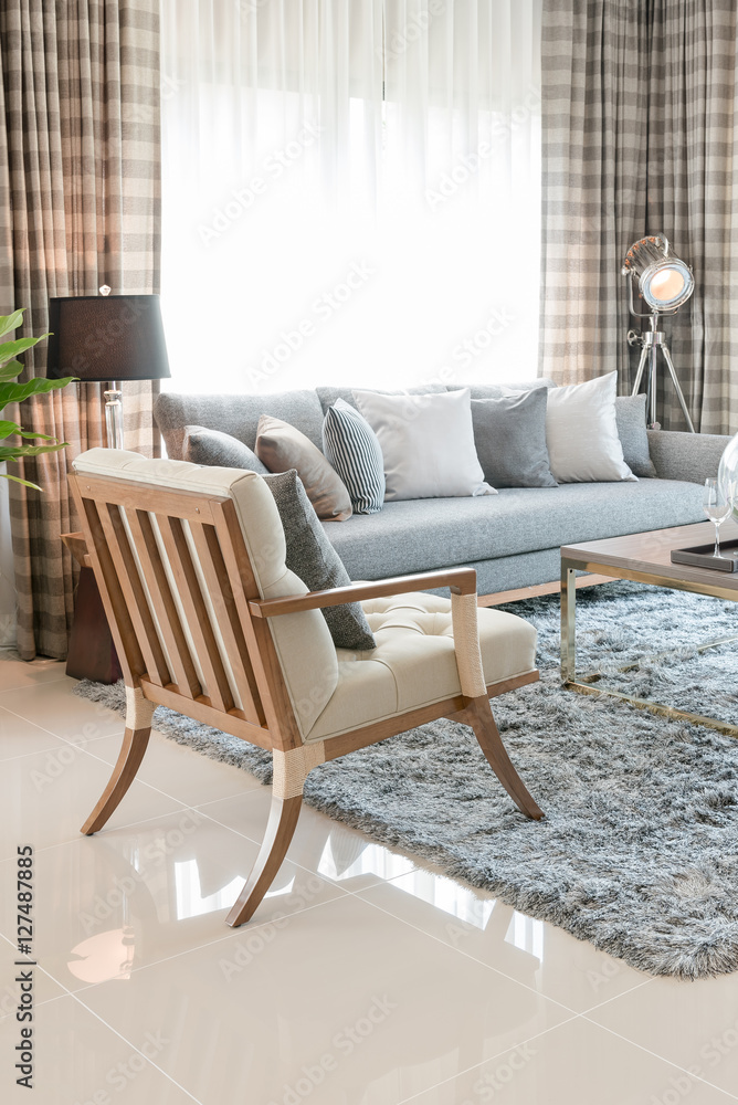 现代客厅，地毯上有木椅