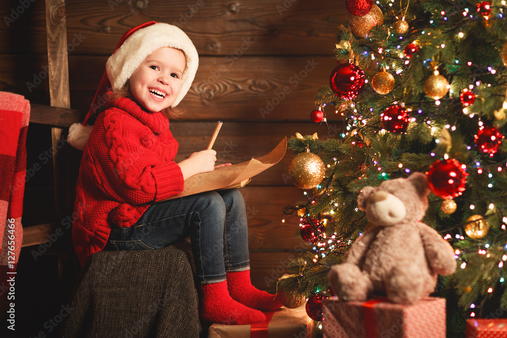 快乐的小女孩在圣诞节给圣诞老人写信