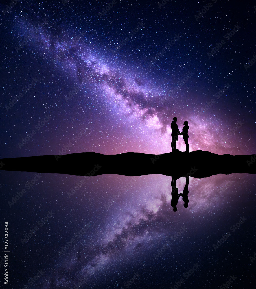 人的轮廓的银河。夜晚星空和男人和女人牵手的风景