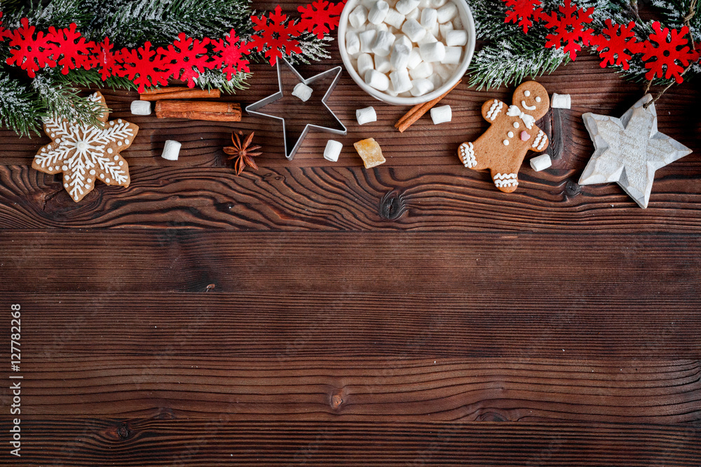 圣诞姜饼，深色木质背景上的云杉树枝俯视图