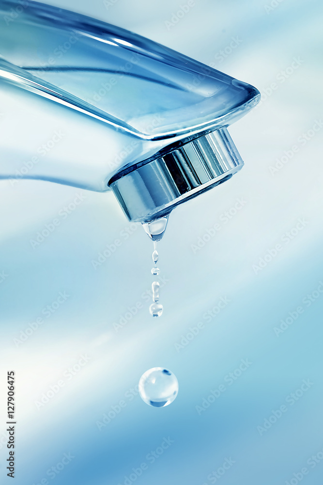 水滴从厨房或浴室附近水槽的镀铬水龙头滴下。