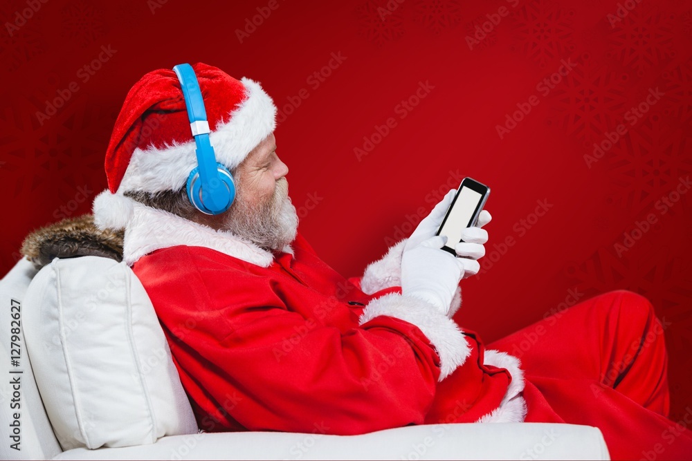 圣诞老人使用带耳机的手机的合成图像