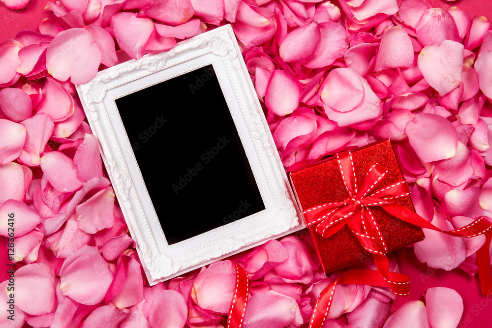空相框，带甜粉色玫瑰花瓣和红色礼盒