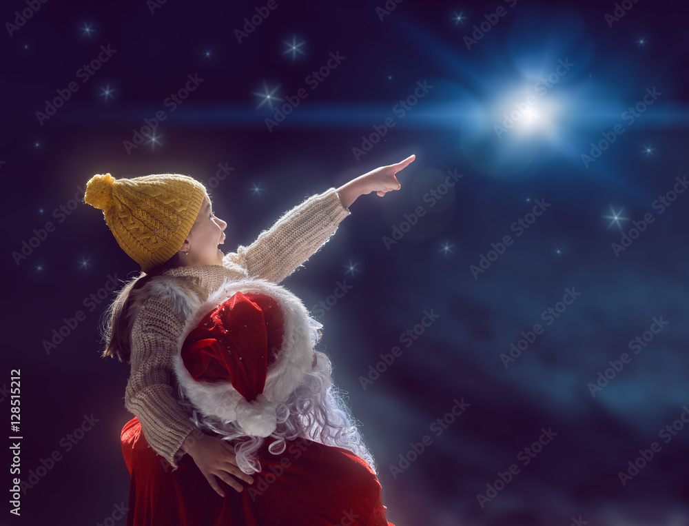 女孩和圣诞老人看着圣诞星