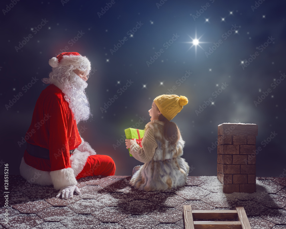 女孩和圣诞老人坐在屋顶上