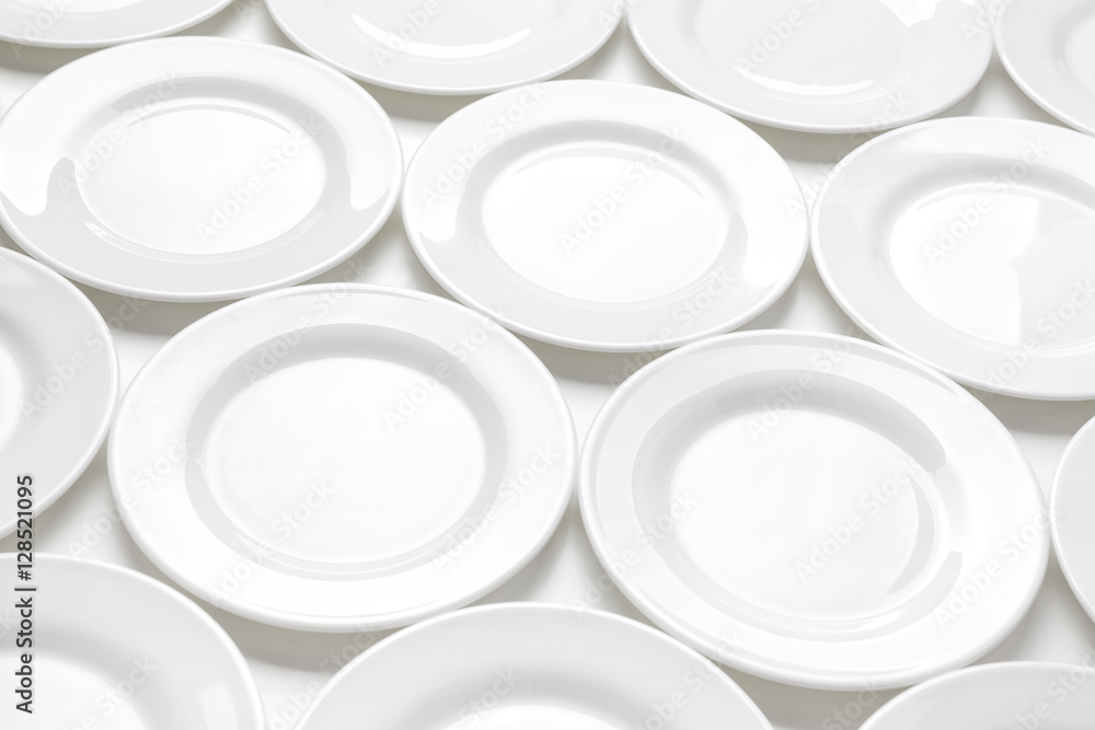 桌子上有很多白色盘子，盘子的图案