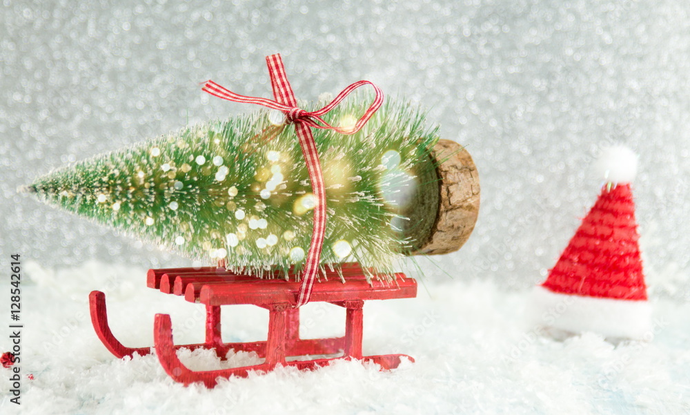 红色雪橇载着一棵小圣诞树