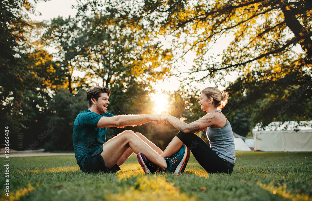 Young couple exercising together at park