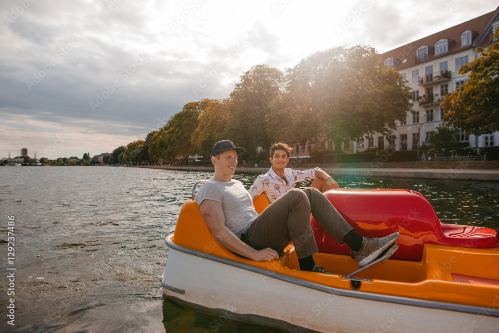 十几岁的男孩在城市的湖面上划船