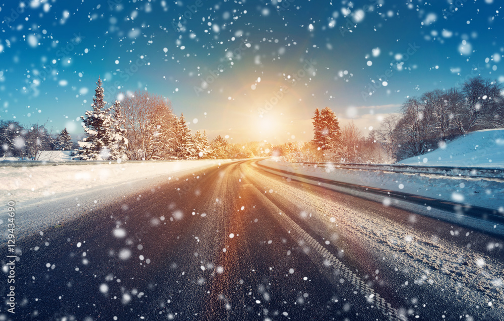 汽车在被雪覆盖的冬季道路上行驶