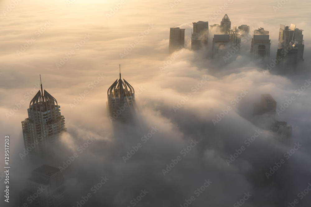 迪拜码头天际线和日出前的摩天大楼上空罕见的清晨冬雾