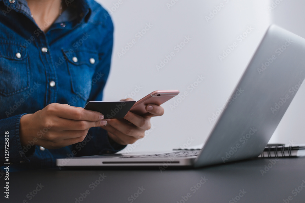 女性使用手机和信用卡在线购物