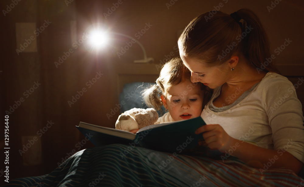 母亲和小女孩在床上看书