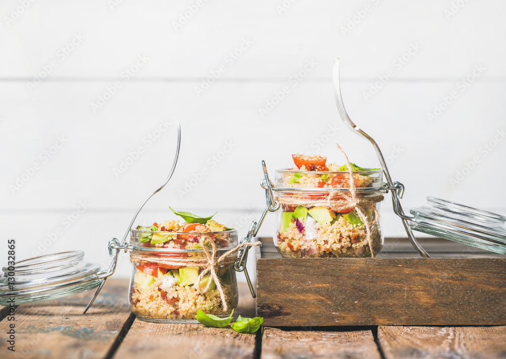 Healthy homemade jar quinoa salad with sun-dried and cherry-tomatoes, avocado and fresh basil. Detox