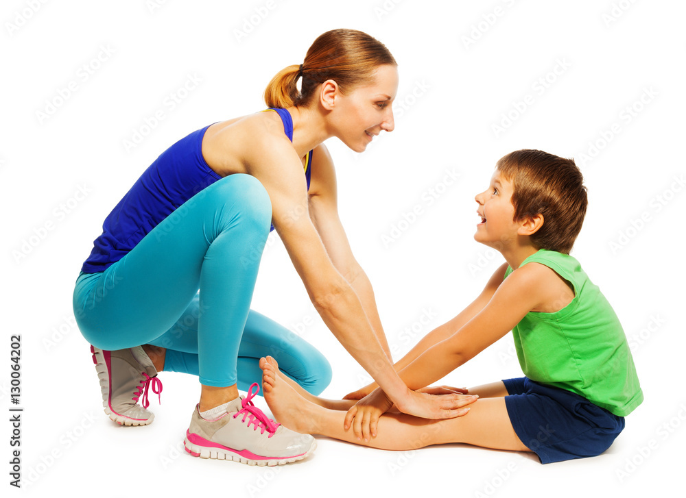 Female trainer teaching kid boy stretching muscles